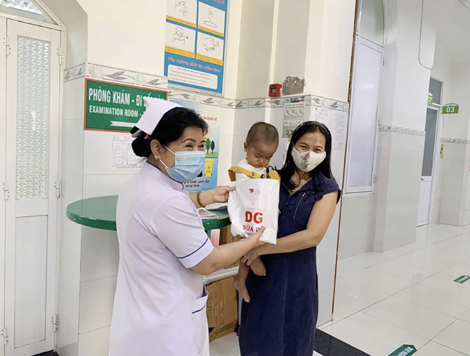 Nhân viên y tế trao trực tiếp phần quà cho phụ huynh và bệnh nhi tại bệnh viện.