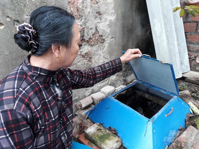 Cứ 2 - 3 ngày, bà Hương lại đưa rác hữu cơ đựng ở trong thùng ra đổ vào hố xử lí và tưới chế phẩm sinh học xuống hố để xử lí rác hữu cơ thành phân bón. Ảnh: Mai Chiến.