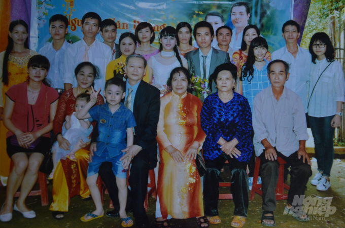 Ông Minh mặc comple ngồi hàng đầu, cạnh bà vợ mặc áo dài (bên phải) cùng họ hàng, các con cháu. Ảnh: Nhân vật cung cấp.