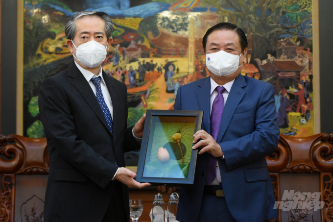 Minister Le Minh Hoan gives Ambassador Xiong Bo a lotus souvenir. Photo: Tung Dinh.