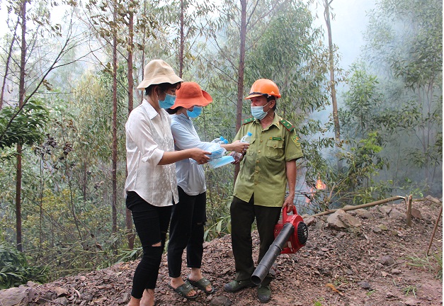Thanh niên tình nguyện thôn Tiên Phong, xã Nội Hoàng tới hiện trường vụ cháy để trao nước uống và khẩu trang miễn phí cho các lực lượng tham gia dập lửa cứu rừng. Ảnh: DĐT.