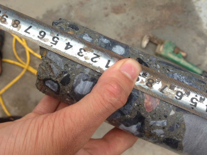 Độ dày của bê tông tại thời điểm khoan kiểm tra chất lượng công trình sau thi công tại một đoạn đường dày 16cm, trong khi thiết kế là 22cm. Ảnh: Trọng Thể.