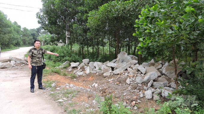 Bê tông thải vẫn chưa được doanh nghiệp thu dọn sau khi phải đào lên từ một đoạn đường phải sửa chữa ở xóm La Lang. Ảnh: Đào Hoàng.