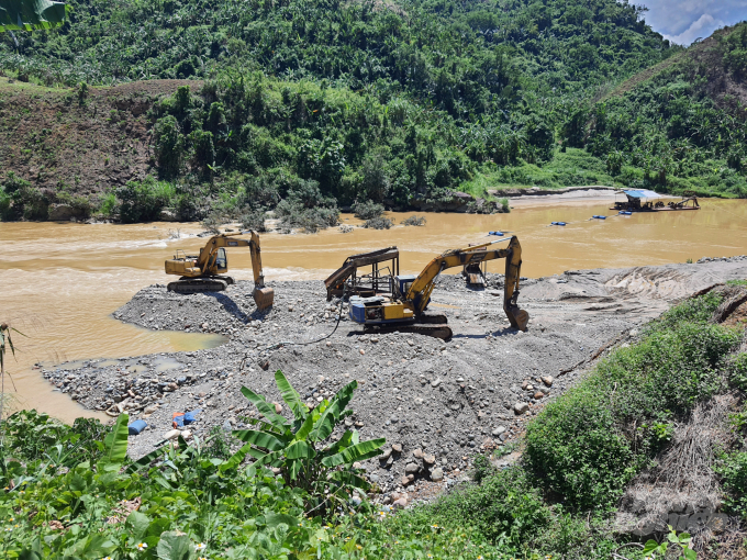 Công ty Cổ phần đầu tư và thương mại Sơn Lâm đắp đất đá, di chuyển giữa dòng sông khai thác khoáng sản. Ảnh cắt clip.