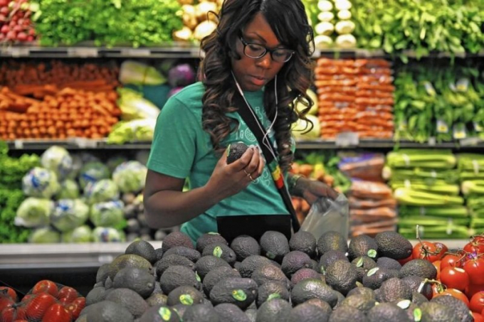  Một người tiêu dùng đang băn khoăn lựa chọn mua trái cây. Ảnh: Los Angeles Times