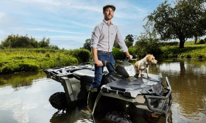 Joe Garland lái xe quad kiểm tra trang trại Mythe ở Warwickshire. Ảnh: Guardian.