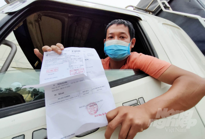 Driver Nguyen Viet Cao Hung with a new negative test certificate. Photo: Minh Hau.