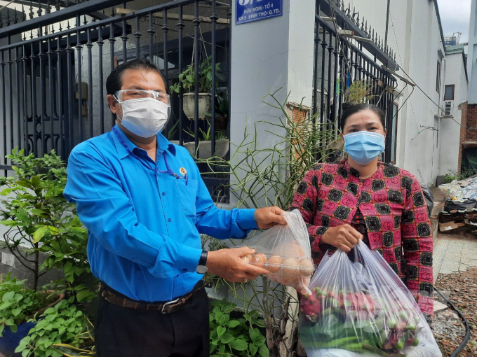 Đại diện Liên đoàn Lao động TP Thủ Đức trao quà từ Chương trình hỗ trợ công nhân cho một công nhân đang lưu trú tại một phòng trọ. Ảnh: Minh Sáng.