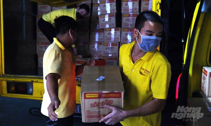 Nhân viên của một công ty chế biến và kinh doanh thực phẩm tại Hà Nội tranh thủ vận chuyển hàng hóa vào đêm. Ảnh: Bảo Thắng.
