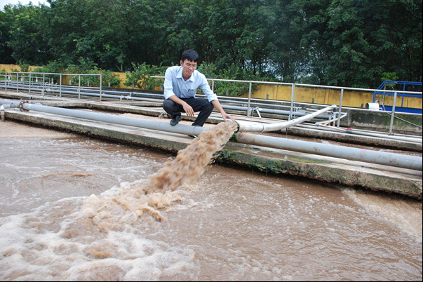Thạc sỹ Nguyễn Quốc Toàn bên công trình ứng dụng sáng kiến 'Giải pháp công nghệ xử lý nước thải cao su thiên nhiên bằng phương pháp sinh học không sử dụng hóa chất và tái sử dụng nước thải cho sản xuất'. Ảnh: Quốc Toàn.