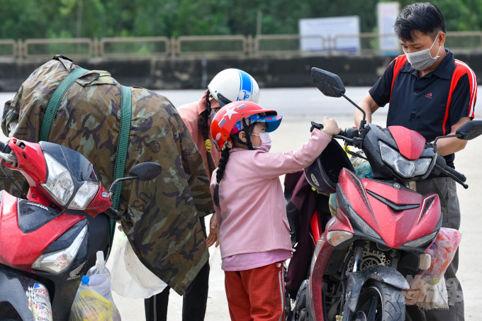 Một cặp vợ chồng cùng con nhỏ đi trên 2 chiếc xe máy, vượt gần 1,4 nghìn km để về Thanh Hóa. Ảnh: VD.