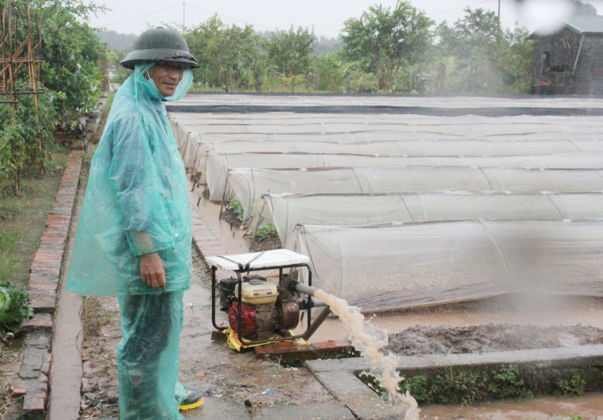 Tại xã Song Phương (Hoài Đức, Hà Nội), người dân túc trực đội mưa nạo vét kênh mương, sử dụng máy bơm hết công suất để bảo vệ các trà rau khỏi ngập sâu. Ảnh: Trung Quân.