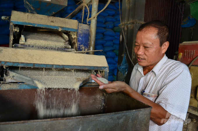 Ông Đỗ Khắc Dũng - Giám đốc HTX Nam Thành kiểm tra gạo sau xay xát. Ảnh: Dương Đình Tường.