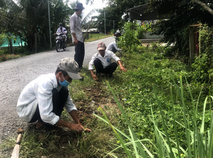 Người dân tích cực tham gia dọn dẹp vệ sinh môi trường trong xây dựng nông thôn mới. Ảnh: MĐ.