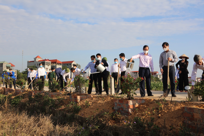 Lãnh đạo địa phương và các doanh nghiệp tài trợ trồng cây phân tán tại đường giao thông tại buổi lễ. Ảnh: Thanh Hương.