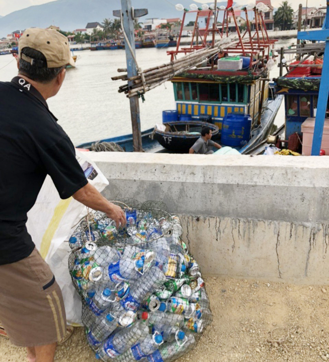 Ngư dân xã Cảnh Dương thực hiện thu gom rác thải trên tàu cá. Ảnh: A.Tuân.