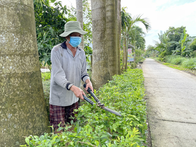 Người dân xã Tân Phú, thị xã Long Mỹ cắt tỉa cây xanh, xây dựng tuyến đường đẹp ở ấp. Ảnh: Hoàng Nhân.