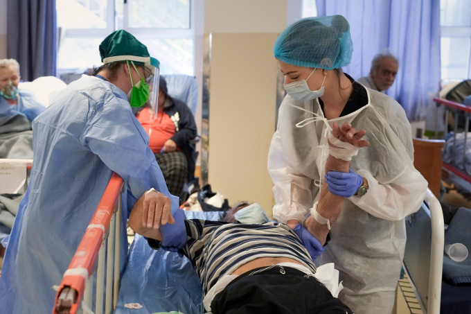 Nhân viên y tế chăm sóc cho một bệnh nhân trong phòng cách ly Covid-19 tại khoa cấp cứu Bệnh viện Đại học Bucharest, Romania. Ảnh: AP.