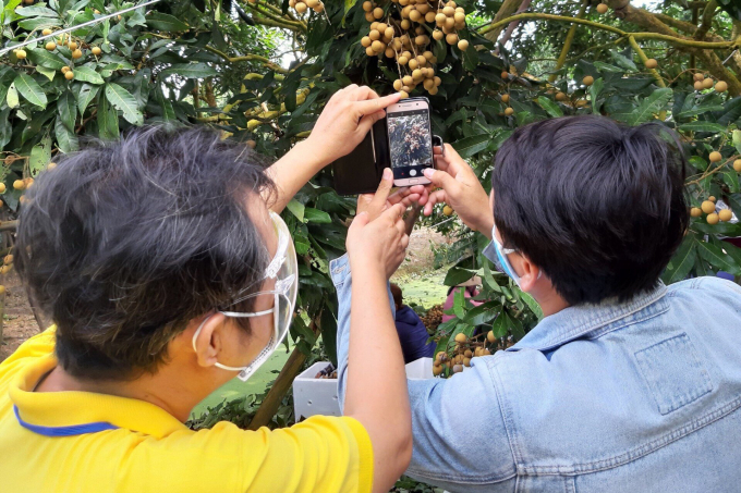 Nhân viên Vietnam Post cùng bà con nông dân chụp ảnh sản phẩm cho gian hàng trên Postmart.vn.