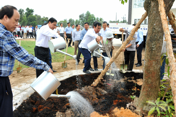 Nguyên Bộ trưởng Bộ NN-PTNT Nguyễn Xuân Cường (cầm thùng tưới nước, thứ 2 từ trái sang) trồng cây xanh tại công trình thủy lợi Cống âu thuyền Ninh Quới (Bạc Liêu). Ảnh: Lê Hoàng Vũ.