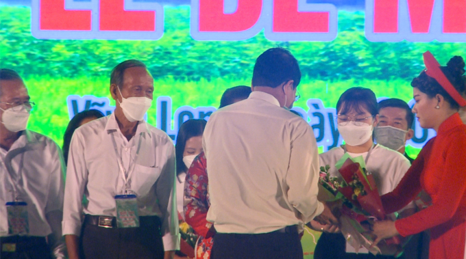 Ban tổ chức trao hoa chúc mừng đội thi của HTX Làng hữu cơ Hiếu Thuận trong cuộc thi gạo ngon thương hiệu Việt tối 10/1/2022. Ảnh: TL.