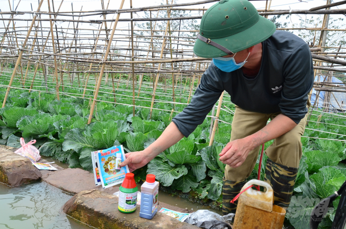 Chai thuốc sâu lậu của Tàu hình tròn trên tay của một nông dân ở xã Yên Phú, huyện Yên Mỹ, tỉnh Hưng Yên. Ảnh: Dương Đình Tường. 