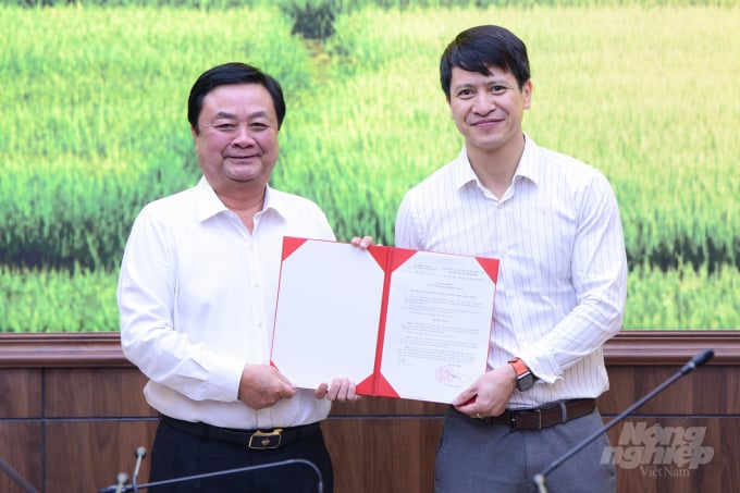 MARD Minister Le Minh Hoan hands over the appointment decision to Mr. Nguyen Minh Tien (right). Photo: Tung Dinh.