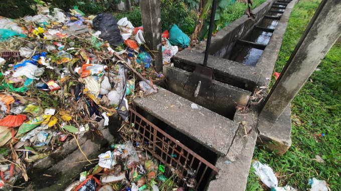 Người dân và cán bộ thôn Núi Thành đã dùng tấm chắn kim loại để ngăn rác theo dòng kênh sang các địa phương khác. Ảnh: Nguyễn Thành