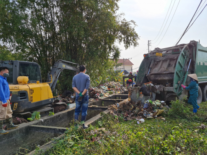 Nhân viên công ty TNHH MTV Thủy lợi Yên Lập thu gom rác tại thôn Núi Thành. Ảnh: Nguyễn Thành