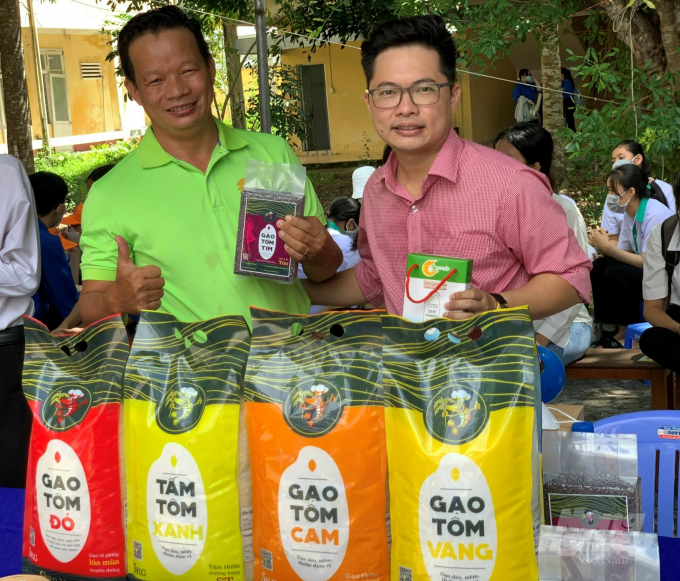 Anh Huỳnh Chí Phương (bên trái) kiên trì giới thiệu sản phẩm hữu cơ từ mô hình tôm - lúa trong lớp trẻ. Ảnh: HL.