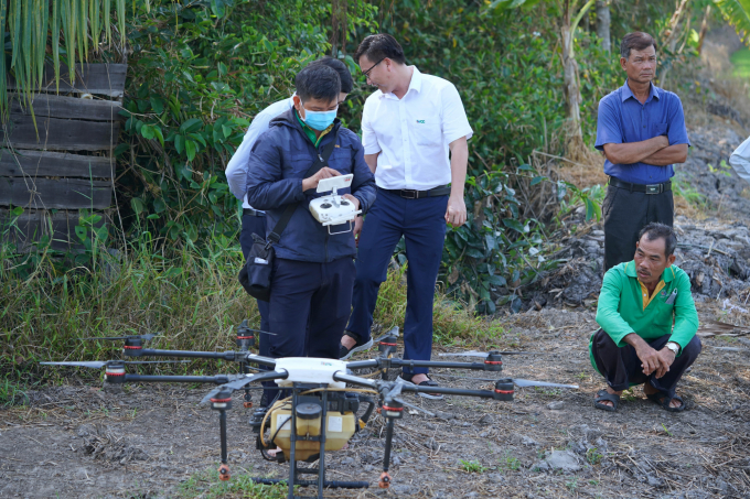 Nhân viên kỹ thuật của Công ty ADC chuẩn bị Drone phun thuốc BVTV trên cánh đồng thực hiên mô hình. Ảnh: Minh Đãm.