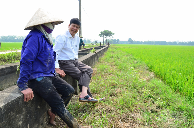 Ông Tiến đang trao đổi bên bờ ruông với chị Nhung. Ảnh: Dương Đình Tường.