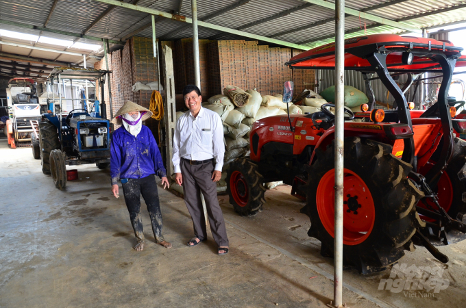 Ông Tiến bên chị Nhung cùng những máy móc cơ giới hóa đồng bộ. Ảnh: Dương Đình Tường. 