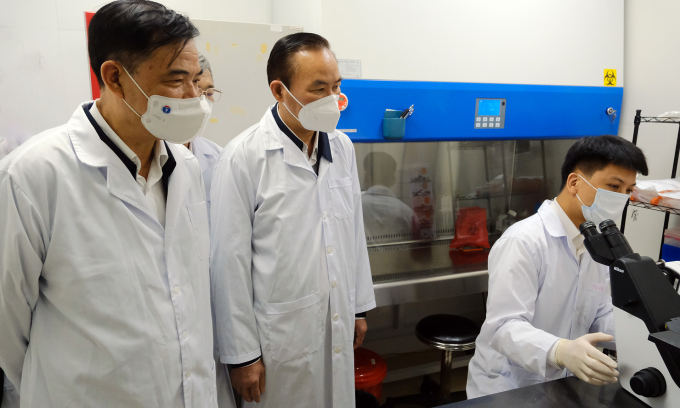 Former Minister of Agriculture and Rural Development Nguyen Xuan Cuong, and Deputy Minister Phung Duc Tien inspect vaccine research at AVAC Vietnam Company. Photo: Bao Thang.