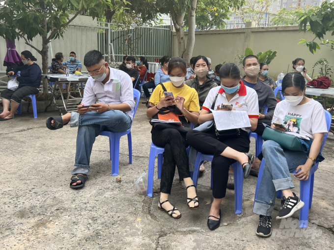 Người lao động ngồi chờ đến lượt làm thủ tục tại BHX TP Thủ Đức. Ảnh: Nguyễn Thủy.