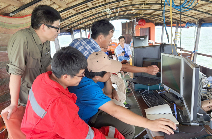 Anh Hoàng Việt - Quản lý Chương trình Nước ngọt và Giám đốc Dự án Khai thác Cát bền vững (đứng sau, đeo kính) cùng Tổ kỹ thuật làm việc. Ảnh: Ngọc Thắng.