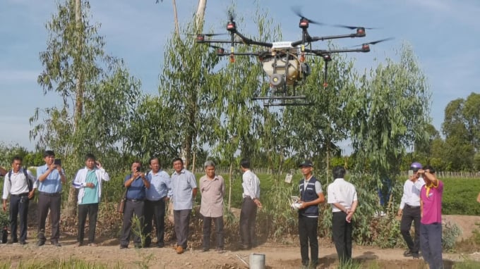 Nông dân rất hào hứng do những chiếc drone tỏ ra tiện dụng, phí dịch vụ thấp khi phun thuốc BVTV. Ảnh: Trọng Trung.