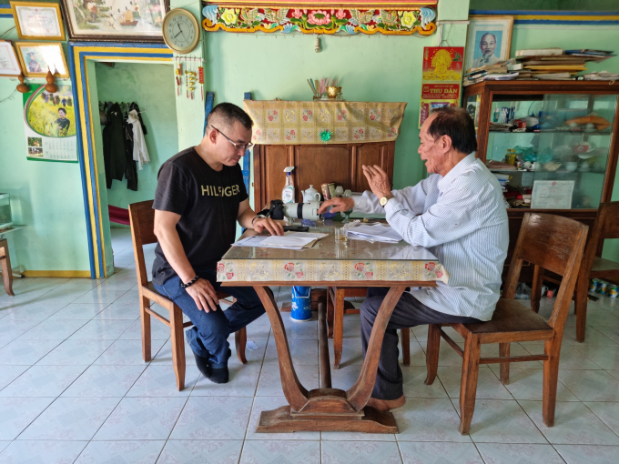 Ông Nguyễn Văn Thinh (bên phải) đang lật giở những tư liệu lịch sử liên quan đến công chúa Bàn Tranh và say sưa kể với tác giả. Ảnh: Trần Thắng. 