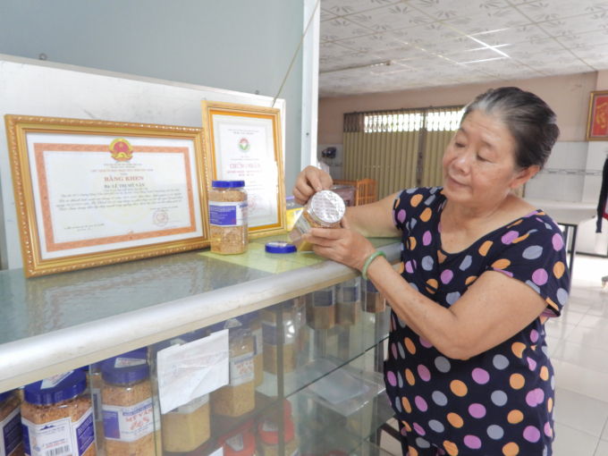 Bà Mỹ Vân giới thiệu sản phẩm tiêu biểu của cơ sở đã được đăng ký nhãn hiệu, đảm bảo vệ sinh an toàn thực phẩm. Ảnh: Trần Trung.