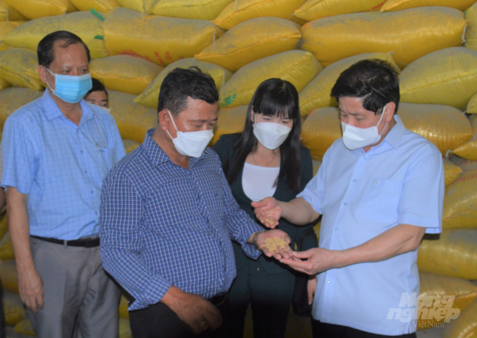 Thứ trưởng Lê Quốc Doanh (ngoài cùng bên phải) kiểm tra lúa đang lưu trữ trong kho của HTX Nông nghiệp Phước Lộc được Dự án VnSAT hỗ trợ đầu tư. Ảnh: Trung Chánh.