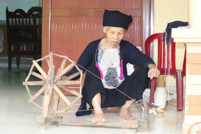 Cụ Lý Thị Tày vẫn hàng ngày xe sợi để giữ gìn nghề dệt vải cho con cháu. Ảnh: H.Đ.