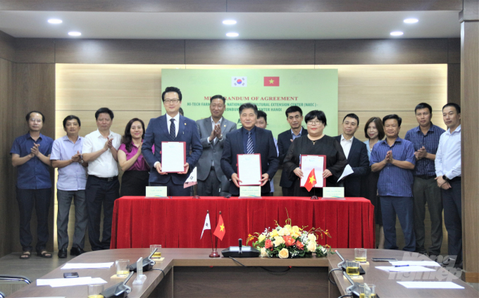 Đại diện Trung tâm Khuyến nông Quốc gia, Công ty Hi-Tech Farm và Trung tâm Xúc tiến Thương mại tỉnh Jounbok tại Hà Nội ký kết thỏa thuận hợp tác. Ảnh: Phạm Hiếu.