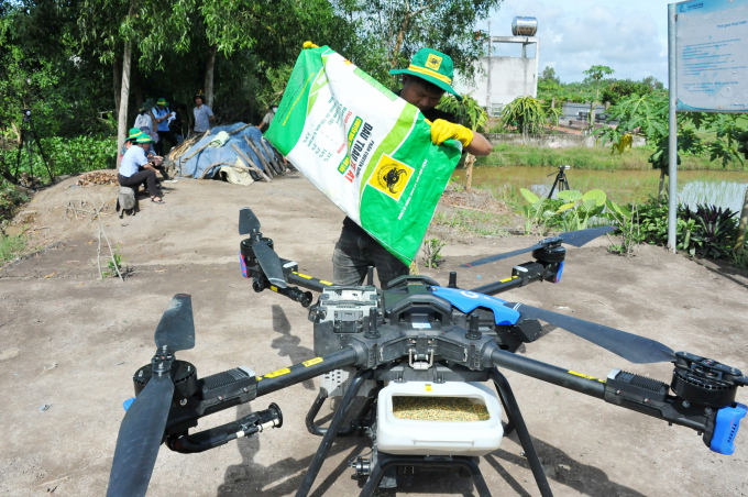 Nhân viên kỹ thuật Công ty Cổ phần Phân bón Bình Điền hỗ trợ bón phân cho nông dân bằng drone. Ảnh: Lê Hoàng Vũ.