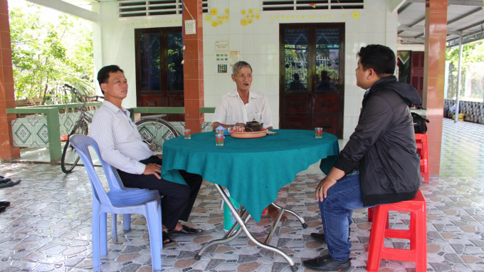 Trong ngôi nhà mới khang trang, ông Nguyễn Văn Hôi (ngồi giữa) kể chúng tôi nghe câu chuyện làm giàu từ cây thanh long. Ảnh: Trần Trung.