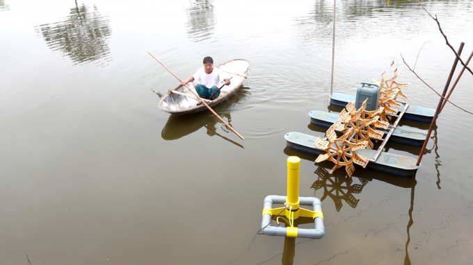 Lão nông Trần Ngọc Thanh chèo thuyền lắp đặt hệ thống cảm biến trong ao cá chép rộng 0,5ha ở xã Tân Phong, huyện Bình Xuyên, Vĩnh Phúc. Ảnh: Quang Dũng.
