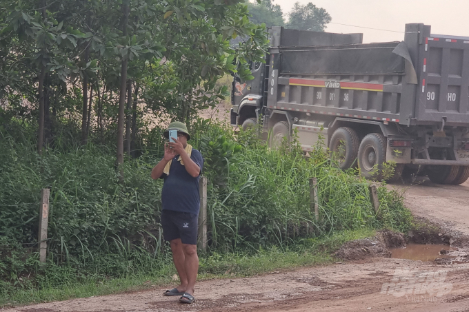 Người đàn ông đi từ mỏ đất Núi Choẹt ra theo dõi, chụp hình lại hoạt động của phóng viên. Ảnh: Toán Nguyễn.