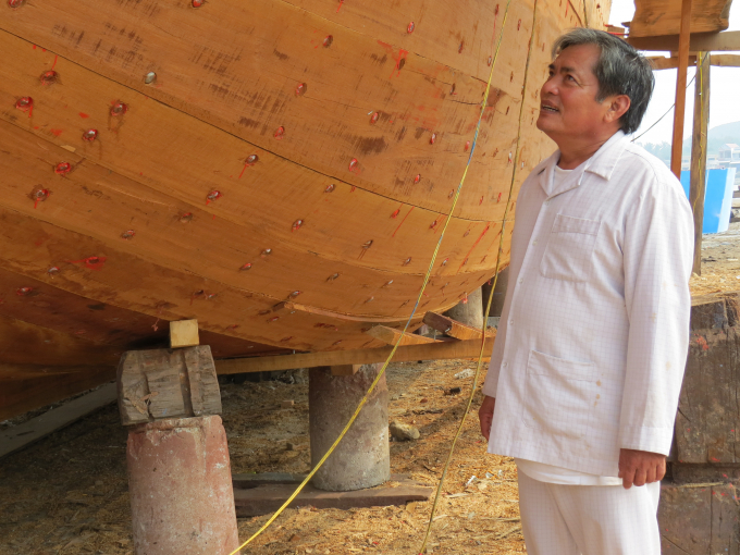 Ông Lê Trung Thành bên con tàu cá đang đóng mới (ảnh chụp 2015). Ảnh: Thanh Kỳ.