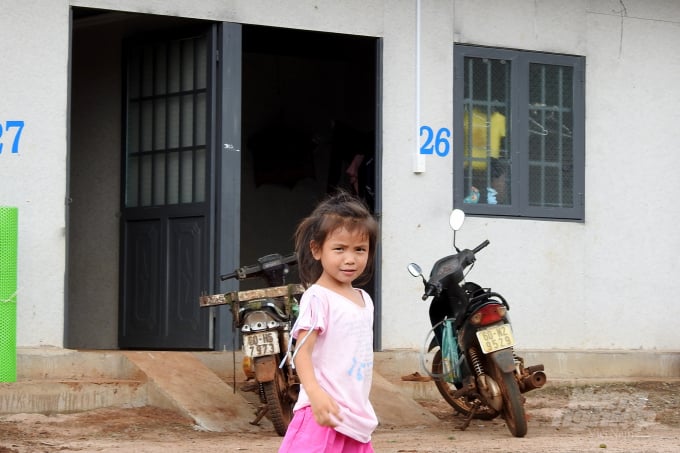 Một bé gái người Hà Giang đứng chơi trong sân một khu nhà ở cho công nhân của Donaruco. Ảnh: Thanh Sơn.