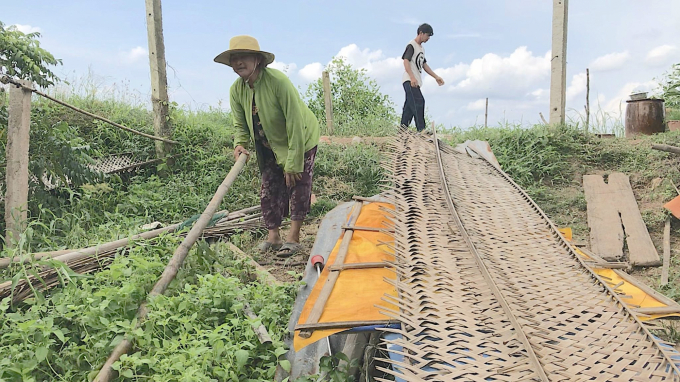 Bà Hoa đang dọn dẹp đồ đạc chuẩn bị dựng lại căn nhà mới. Ảnh: Minh Đảm.