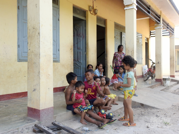 Trẻ em người Campuchia ngồi chơi tại một khu dân cư tập trung dành cho công nhân cao su. Ảnh: Thanh Sơn.